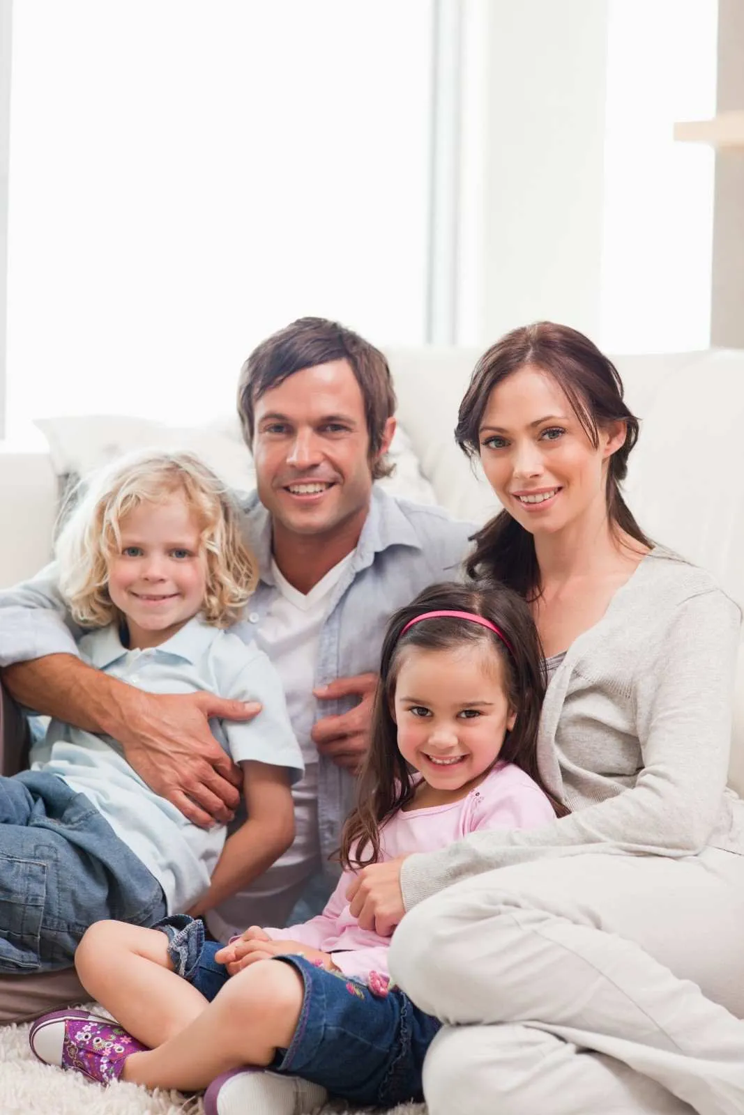 Family of four sitting together at home